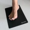 Foot placed on an ELEMENTS® Non-Slip Pad on the floor
