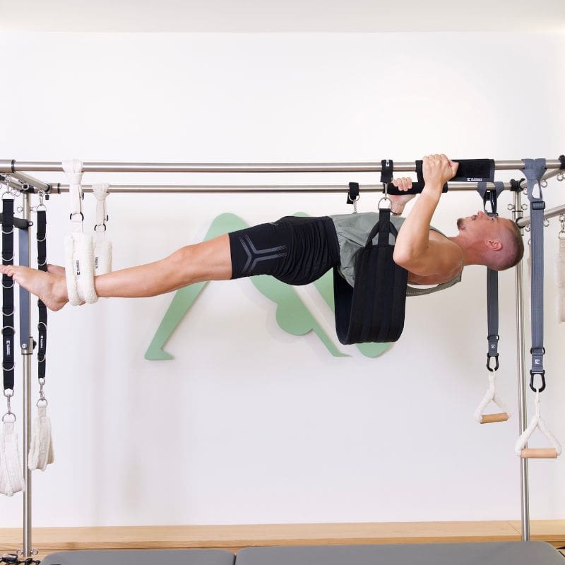 Michael on Pilates Cadillac ELEMENTS® slings, Fuzzies and pads shown in use on a Pilates Cadillac