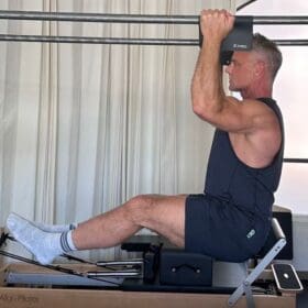 Sean Bergara doing pull-ups on Pilates Cadillac