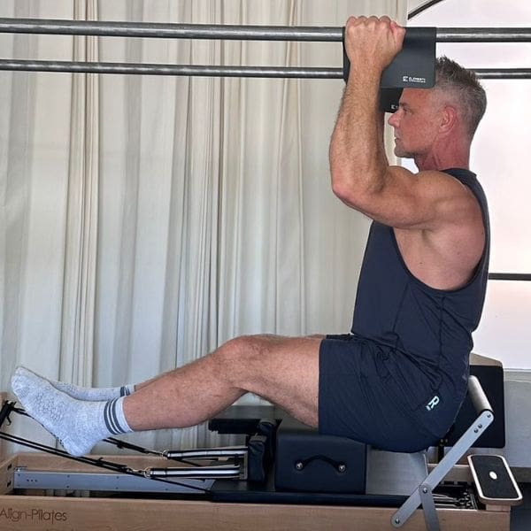 Sean Bergara doing pull-ups on Pilates Cadillac